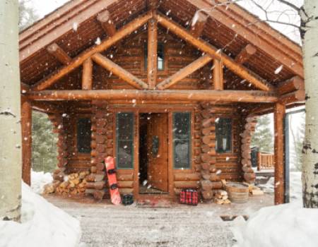 Slopeside Rental in Jackson Hole, snowboard on a porch with firewood