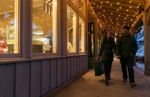 2 people walking by a shop on Jackson Town Square in Jackson Hole Wyoming
